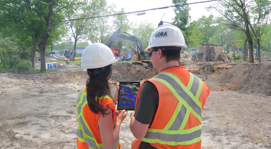 Two professionals reviewing digital blueprints on a tablet for BIM implementation