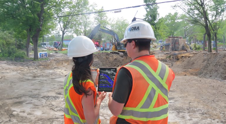 Two professionals reviewing digital blueprints on a tablet for BIM implementation